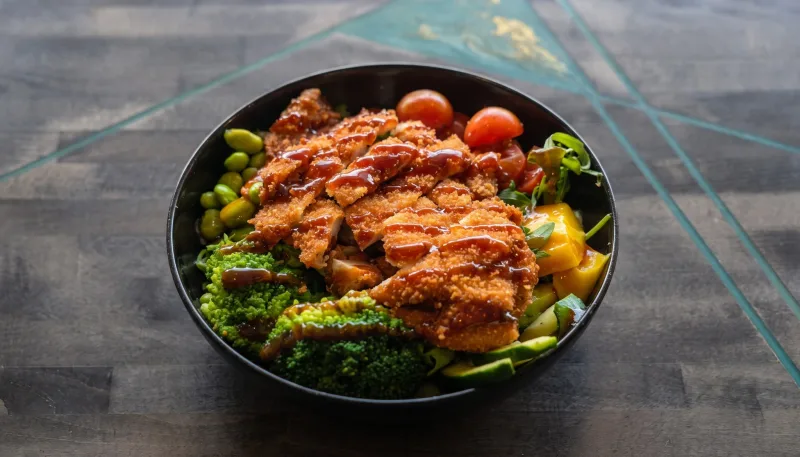Buddha Bowl — Bowl mit Reis, Salatmix, Tomate, Mango, Edamame, Kichererbsen, Brokkoli, Zucchin bei Kaspio in Stade