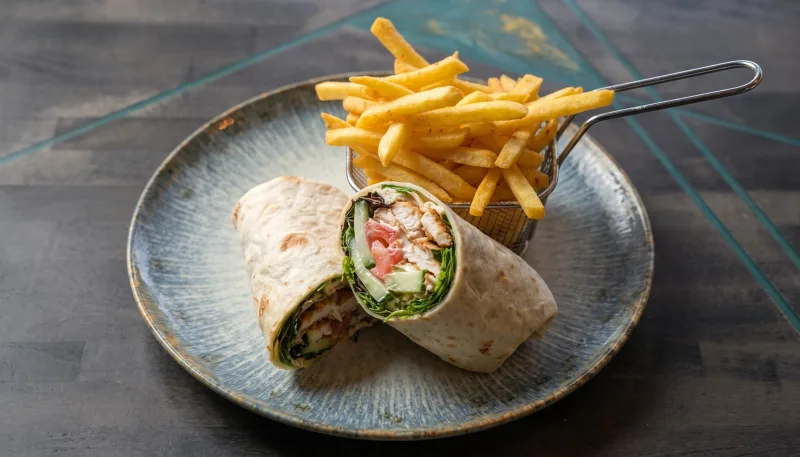 Caesar Wrap — Knuspriges Hähnchen, Mixsalat, Tomate, Gurke, Parmesan, Caesardressing dazu Pomm bei Kaspio in Stade