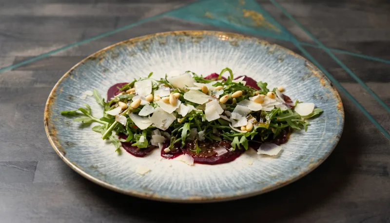 Carpaccio Rosso — Rote-Bete-Carpaccio mit Rucola, Parmesan und Pinienkernen bei Kaspio in Stade