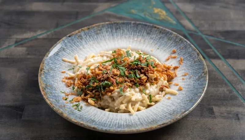 Hausgemachte Käsespätzle — Mit Bergkäse, Emmentaler und Röstzwiebeln bei Kaspio in Stade